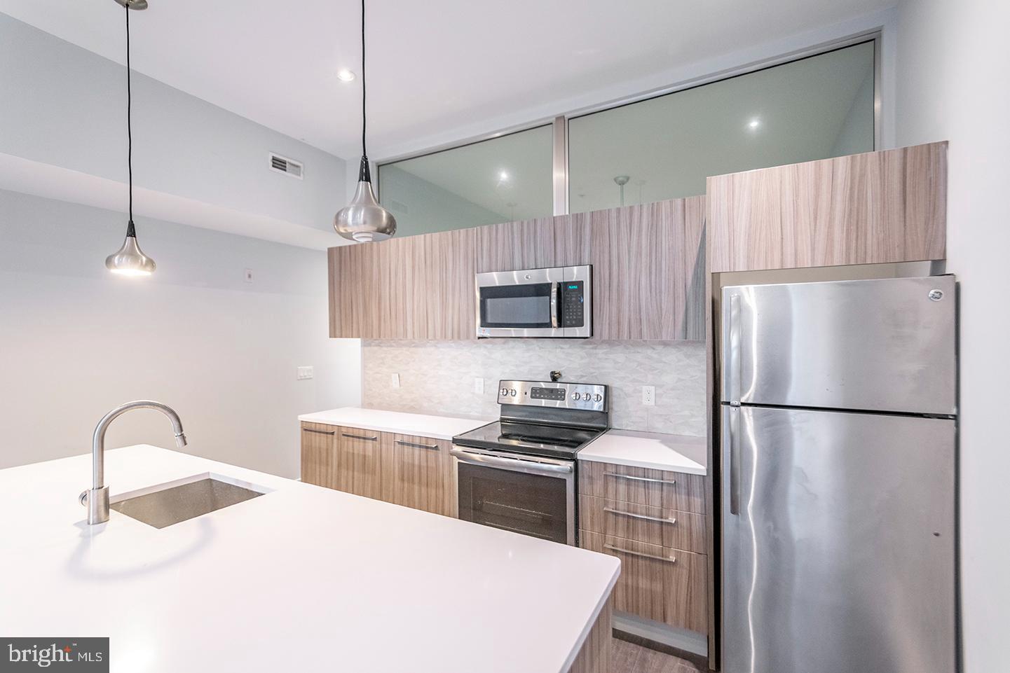 412 South 13th Street, Unit 212 Philadelphia, PA 19147 - Photo 1 of 16 a kitchen with appliances a refrigerator and cabinets