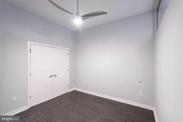 an empty room with a fan & a ceiling fan