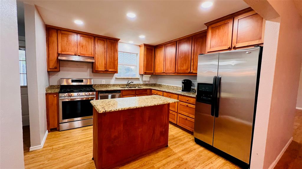 7301 Fishtrap Road Cross Roads, TX 76227 - Photo 14 of 40 a kitchen with stainless steel appliances granite countertop wooden cabinets a stove top oven a sink and dishwasher