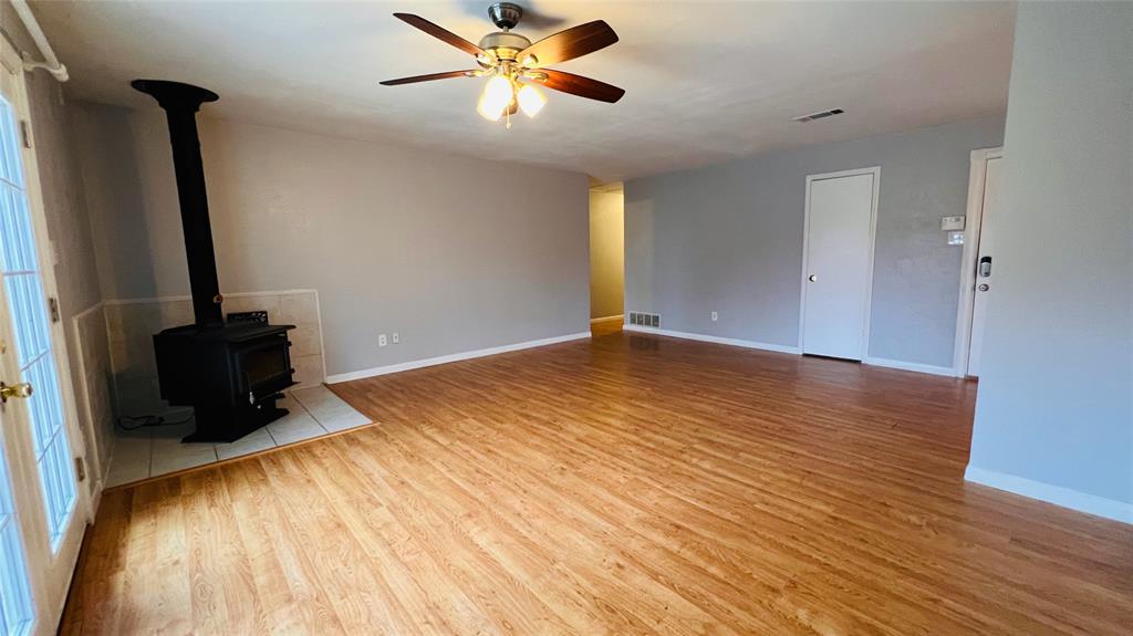 7301 Fishtrap Road Cross Roads, TX 76227 - Photo 18 of 40 a view of an empty room with wooden floor and a ceiling fan