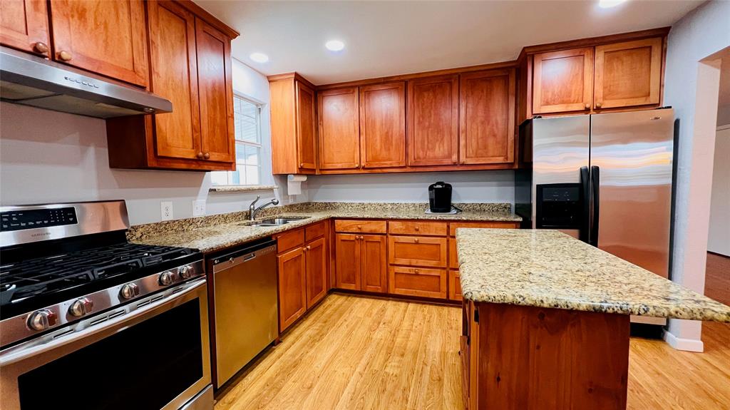 7301 Fishtrap Road Cross Roads, TX 76227 - Photo 28 of 40 a kitchen with stainless steel appliances granite countertop wooden cabinets a stove top oven a sink and dishwasher