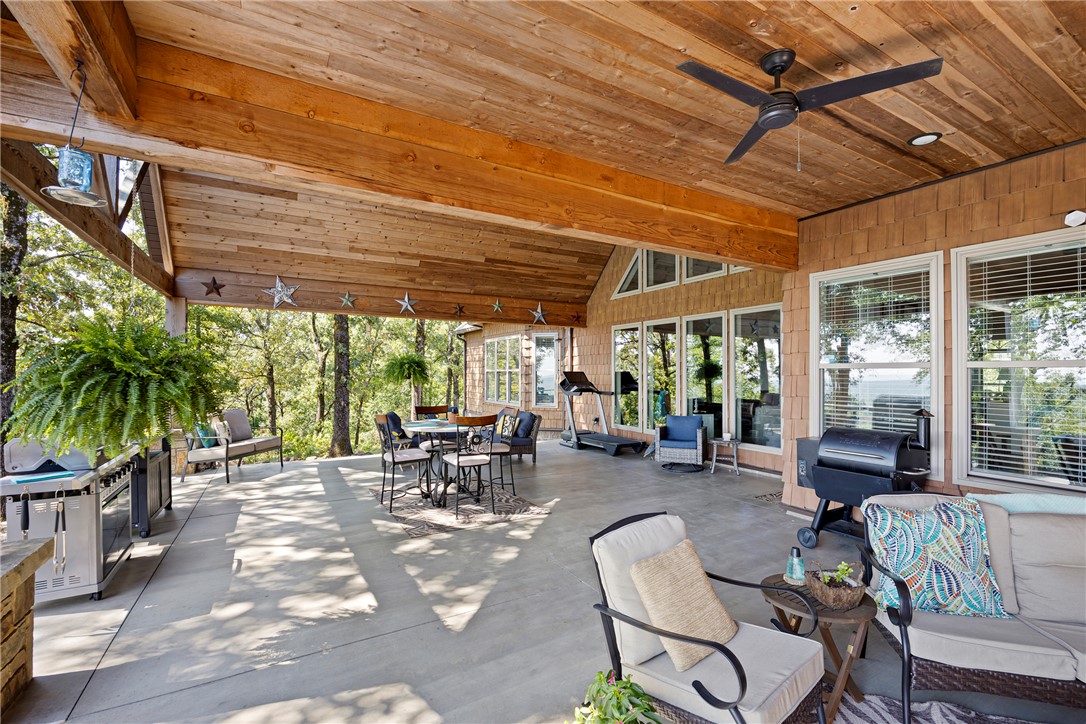 3419 Bailey Loop Road London, AR 72847 - Photo 43 of 60 Expansive covered patio featuring a wood-panel ceiling, exposed wood beams, and a ceiling fan