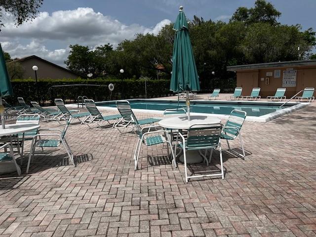2622 North Nob Hill Road, Unit 2622 Sunrise, FL 33322 - Photo 16 of 16 a view of a patio with a dining table and chairs with a fire pit