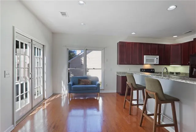 a kitchen with granite countertop wooden floors cabinets and appliances
