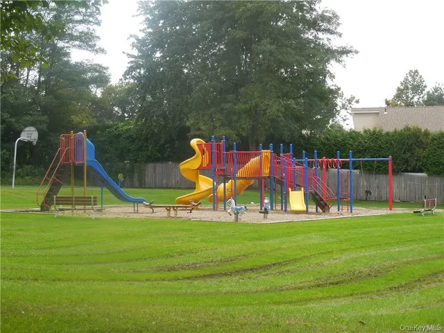 a view of playground with slide and bench