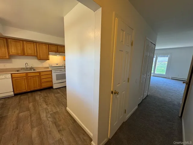 a view of a kitchen with refrigerator stove and wooden floor