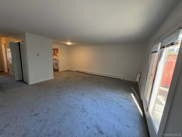 an empty room with a fireplace and windows
