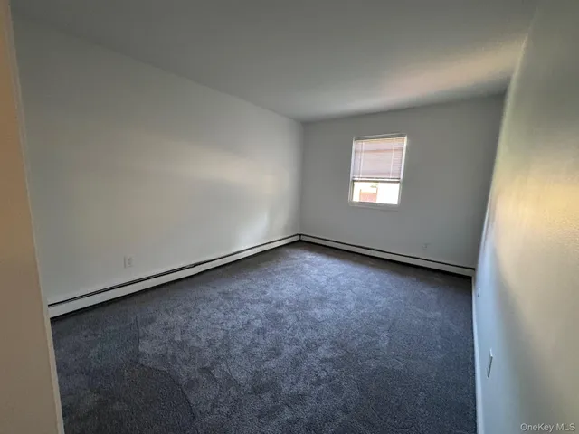 an empty room with stairs and wooden floor