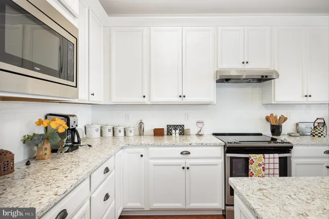 a kitchen with stainless steel appliances granite countertop a sink stove and cabinets