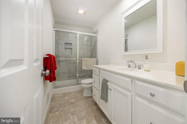 a bathroom with a sink vanity mirror bathtub and toilet