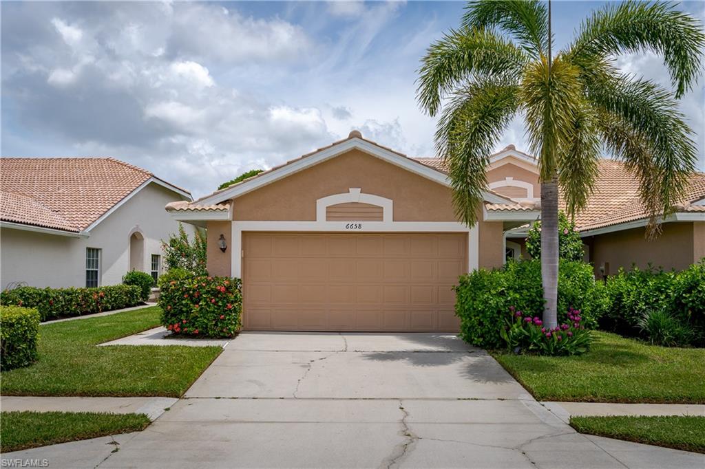 6658 Castlelawn Place, Unit 9 Naples, FL 34113 - Photo 2 of 38 Stucco exterior with a tiled roof, featuring an attached garage and a concrete driveway