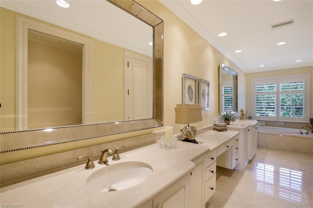 8121 Via Vecchia Naples, FL 34108 - Photo 16 of 35 a bathroom with double vanity sinks a mirror and a bathtub