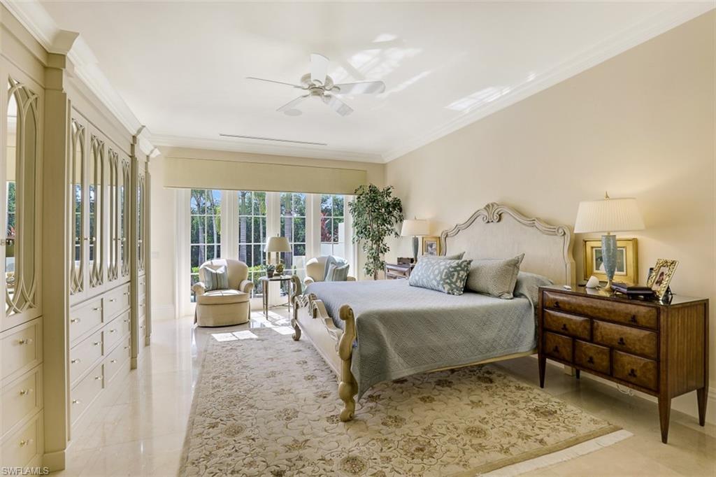 8121 Via Vecchia Naples, FL 34108 - Photo 20 of 35 a bedroom with a bed and a chandelier