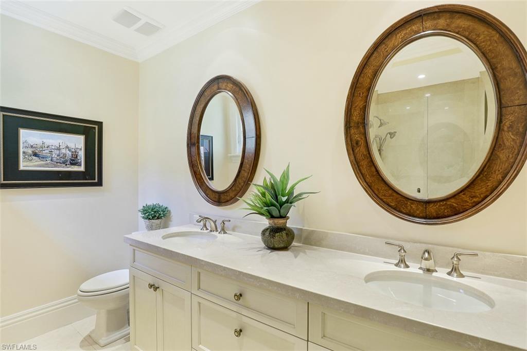8121 Via Vecchia Naples, FL 34108 - Photo 23 of 35 a bathroom with a toilet a sink and a mirror