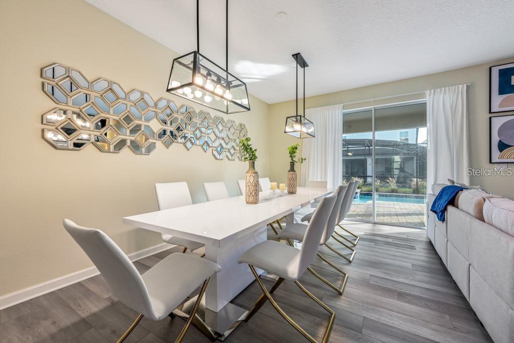 4532 Target Boulevard Kissimmee, FL 34746 - Photo 25 of 52 a dining room with furniture a chandelier and wooden floor