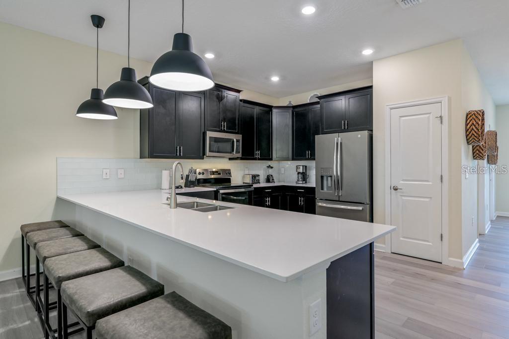 4532 Target Boulevard Kissimmee, FL 34746 - Photo 28 of 52 a kitchen with stainless steel appliances a stove refrigerator and sink