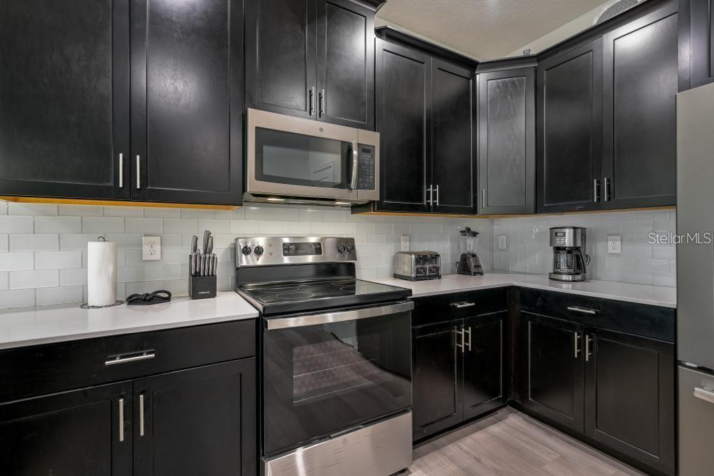 4532 Target Boulevard Kissimmee, FL 34746 - Photo 29 of 52 a kitchen with stainless steel appliances granite countertop a sink stove and microwave