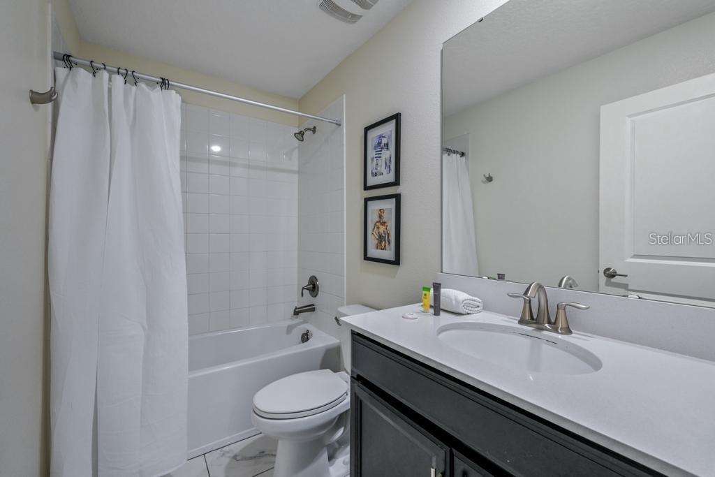 4532 Target Boulevard Kissimmee, FL 34746 - Photo 34 of 52 a bathroom with a granite countertop sink toilet and shower