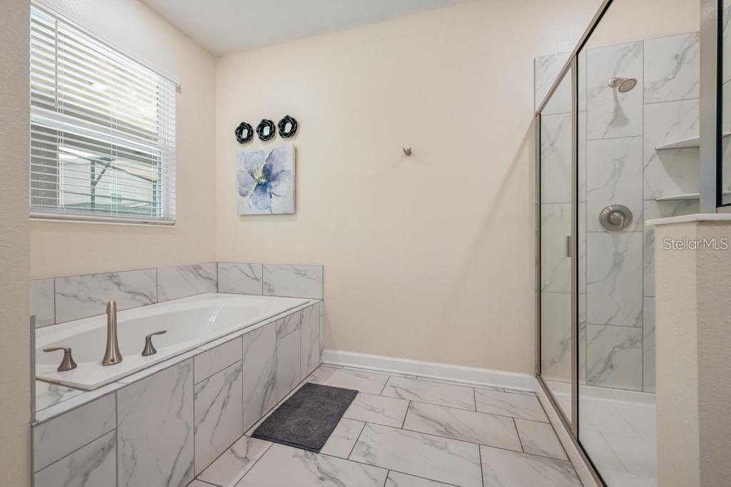 4532 Target Boulevard Kissimmee, FL 34746 - Photo 39 of 52 a bathroom with a tub sink and mirror