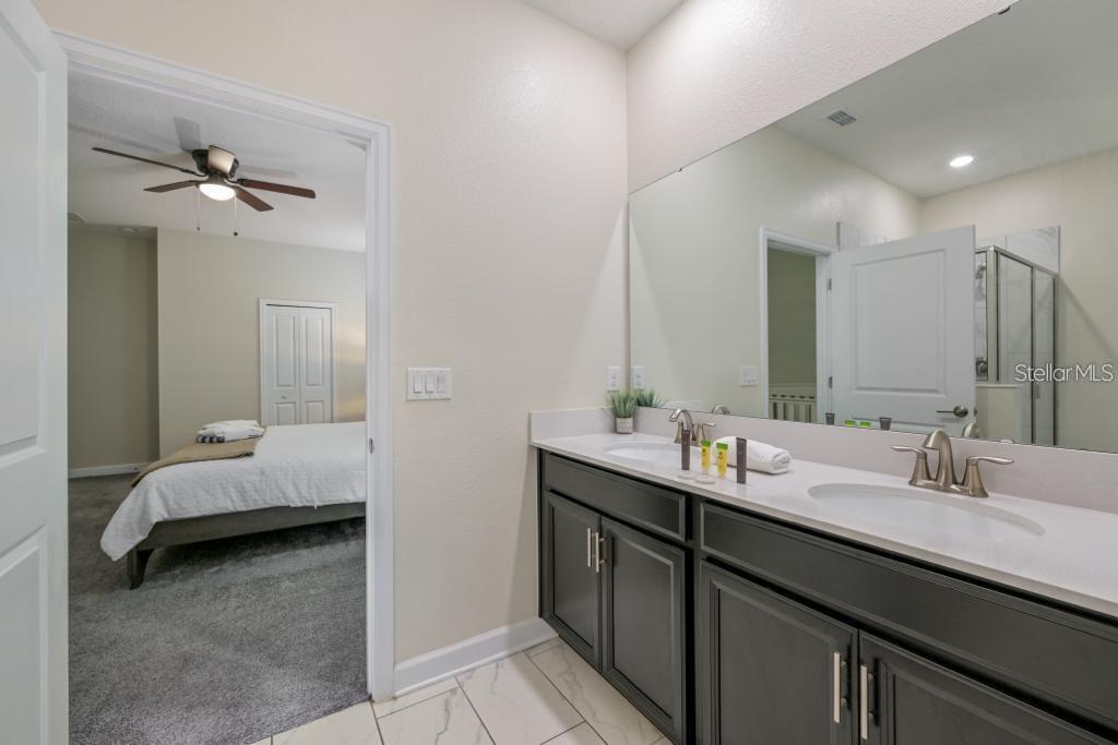 4532 Target Boulevard Kissimmee, FL 34746 - Photo 45 of 52 a en suite bathroom with a double vanity sink and a mirror