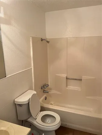 a white toilet sitting next to a bath tub