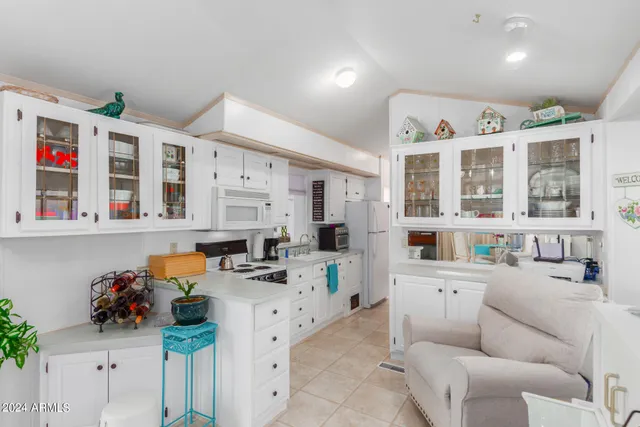 a living room with furniture kitchen appliances and a window
