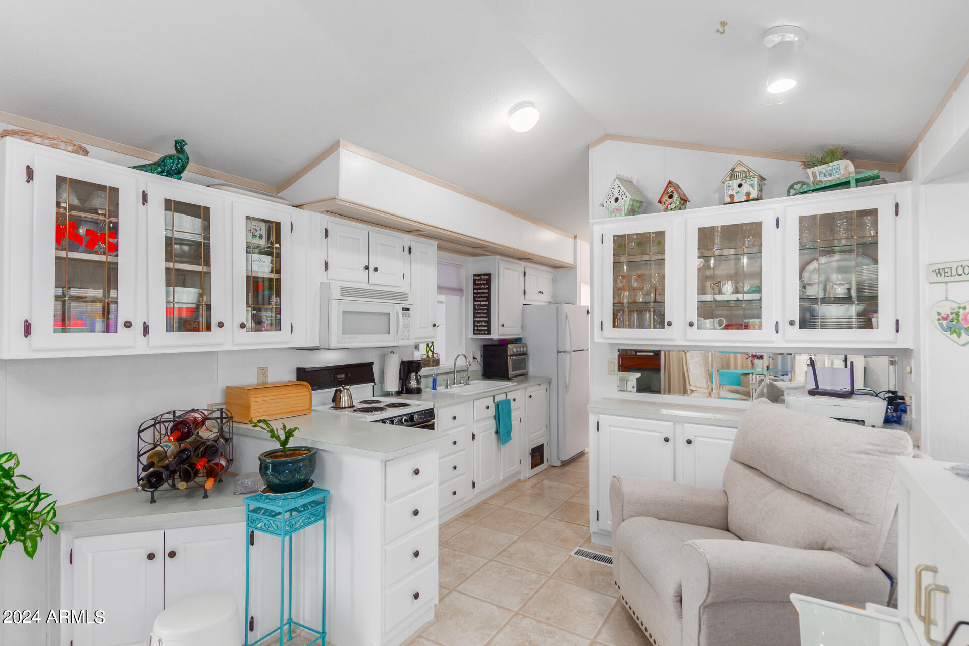 a living room with furniture kitchen appliances and a window