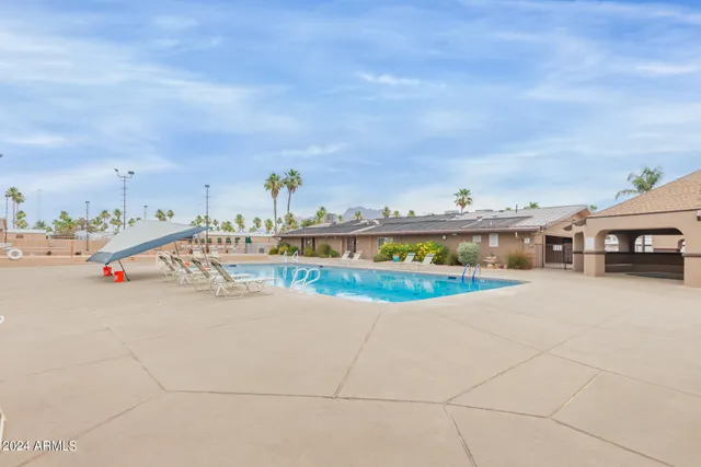 a view of a terrace with lawn chairs and iron fence