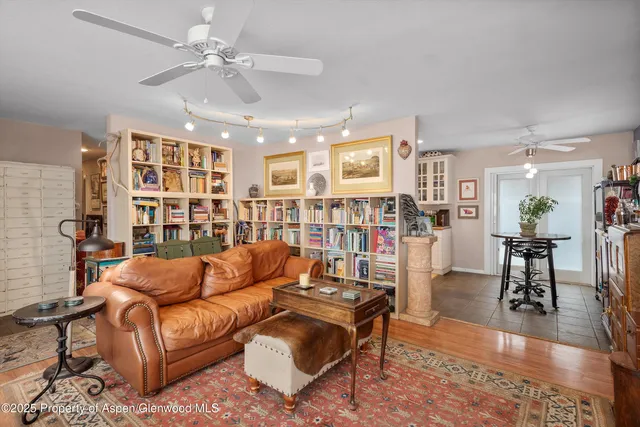 a living room with furniture and a book shelf
