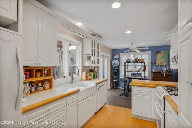 a large kitchen with a lot of counter space and wooden floor
