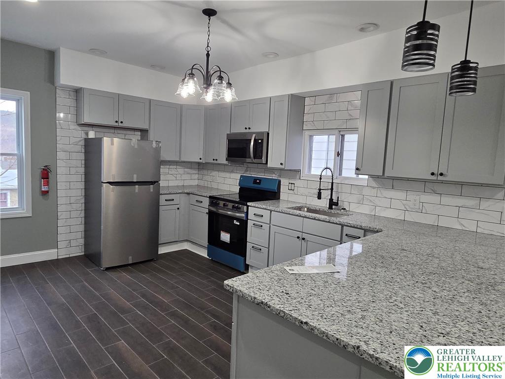 253 East Abbott Street Lansford, PA 18232 - Photo 9 of 43 a kitchen with a center island wooden floor and stainless steel appliances