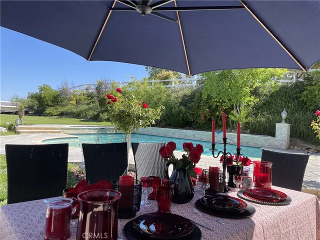a view of an chairs and table under an umbrella