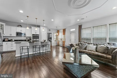 a living room kitchen with furniture and a wooden floor