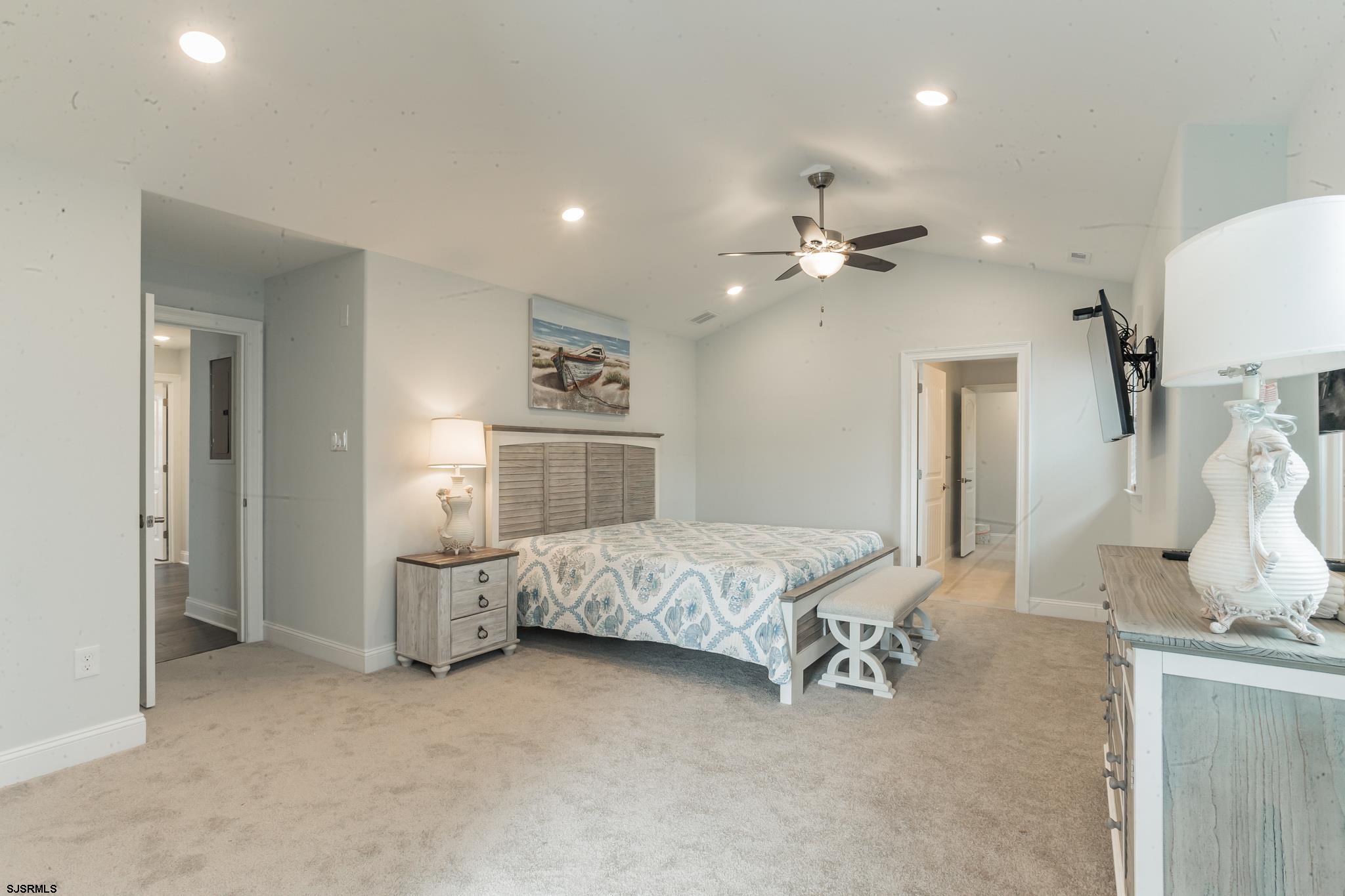 910 Ocean Avenue, Unit C Ocean City, NJ 08226 - Photo 12 of 30 a spacious bedroom with a bed and a chandelier
