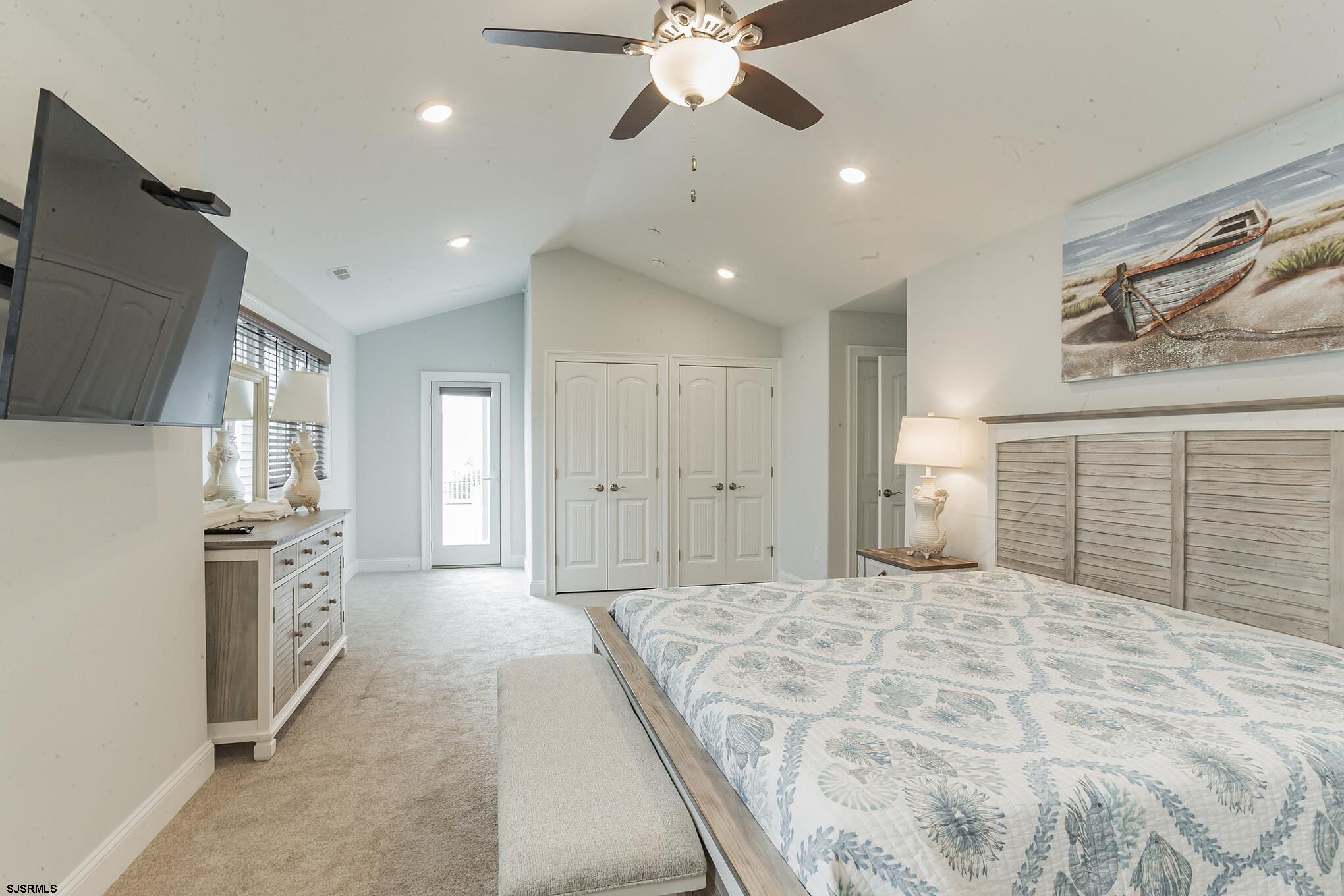 910 Ocean Avenue, Unit C Ocean City, NJ 08226 - Photo 13 of 30 a spacious bedroom with a large bed a chandelier and closet