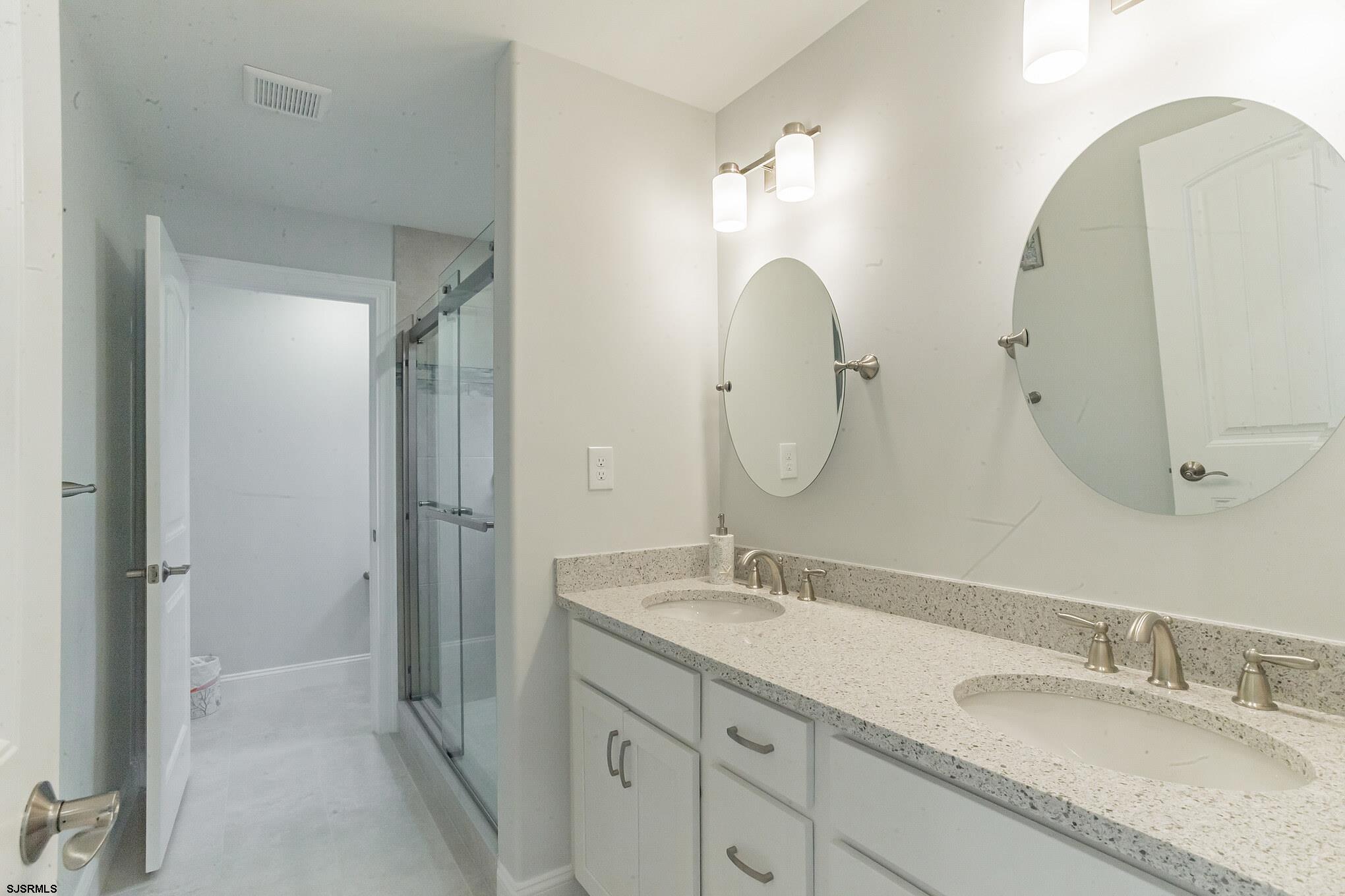 910 Ocean Avenue, Unit C Ocean City, NJ 08226 - Photo 14 of 30 a bathroom with a granite countertop double vanity sink mirror and shower