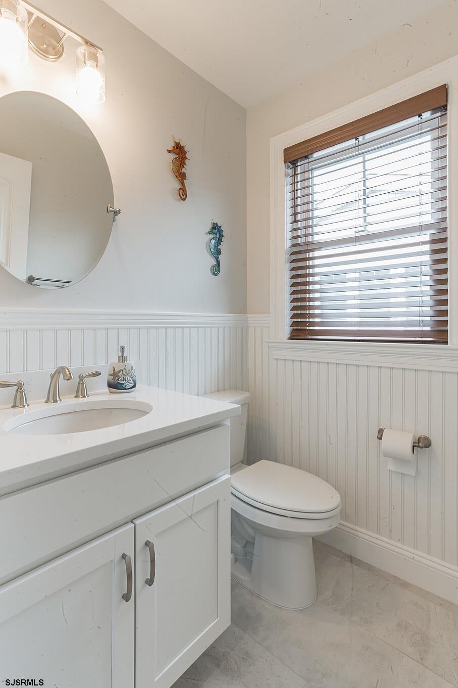 910 Ocean Avenue, Unit C Ocean City, NJ 08226 - Photo 18 of 30 a bathroom with a toilet a sink a mirror and a window