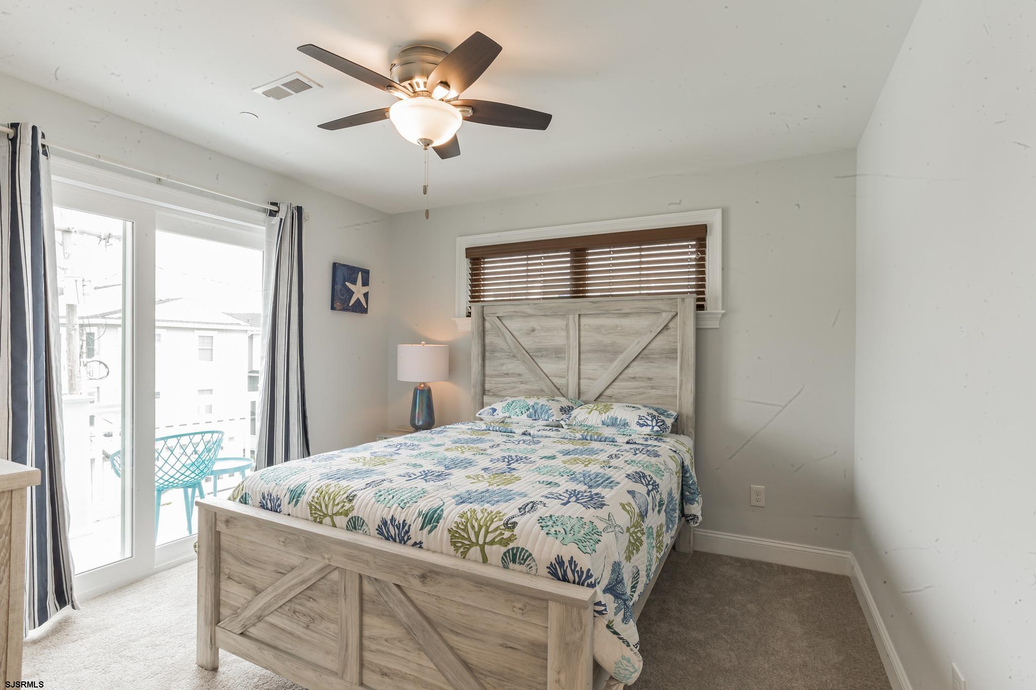 910 Ocean Avenue, Unit C Ocean City, NJ 08226 - Photo 19 of 30 a bedroom with a bed and a chandelier