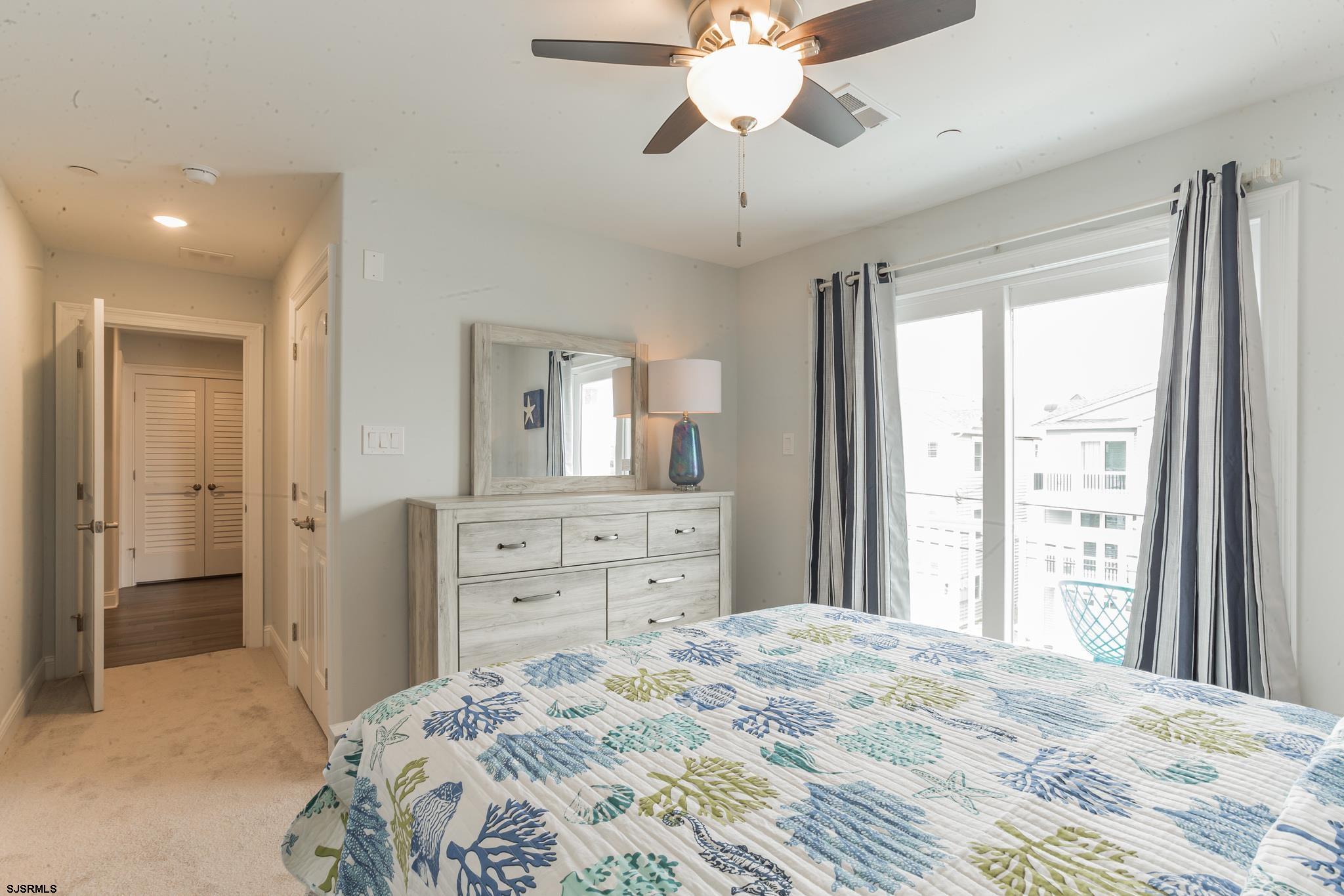 910 Ocean Avenue, Unit C Ocean City, NJ 08226 - Photo 20 of 30 a bedroom with a bed and a chandelier