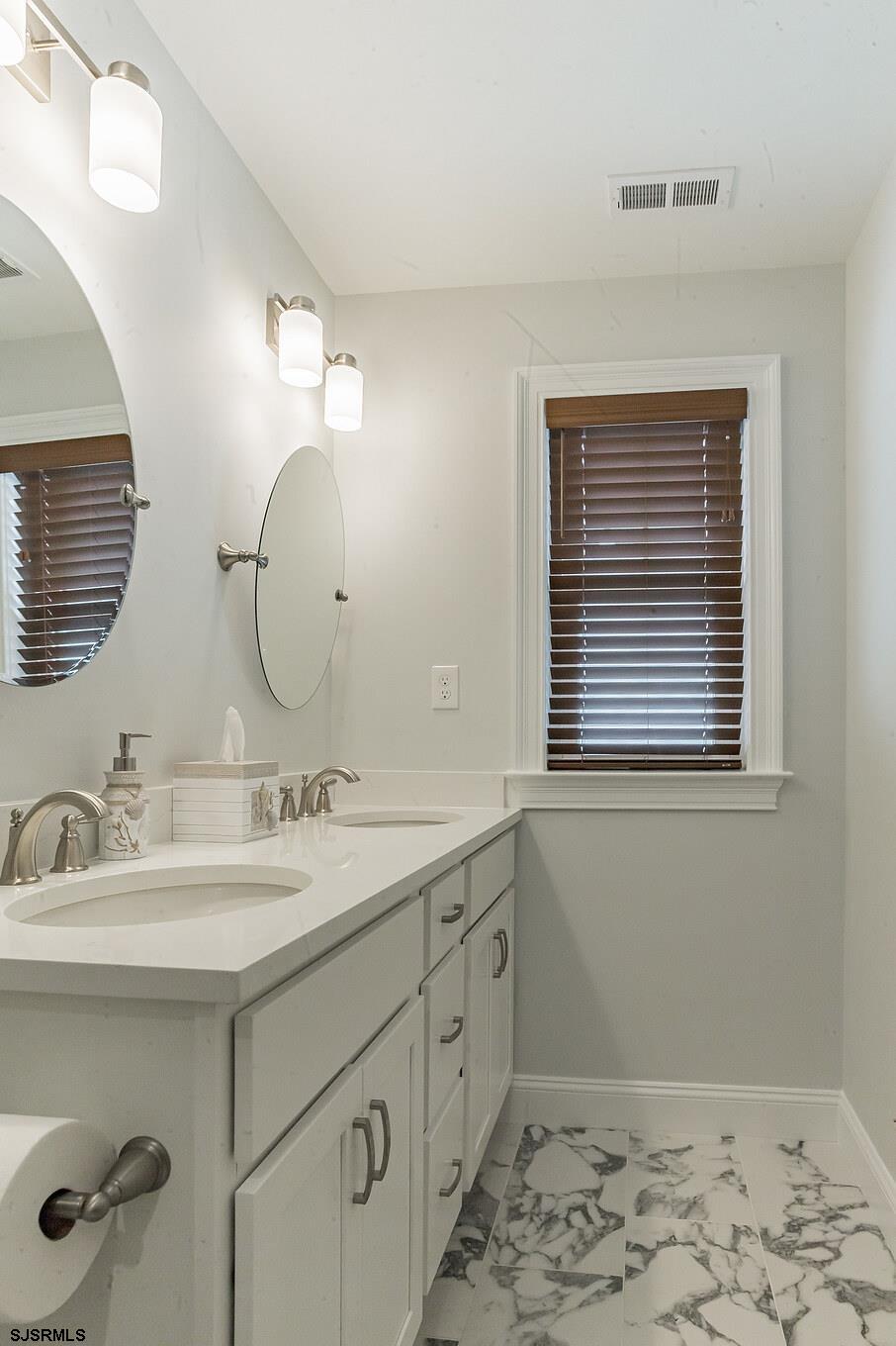 910 Ocean Avenue, Unit C Ocean City, NJ 08226 - Photo 27 of 30 a bathroom with a double vanity sink window and a mirror