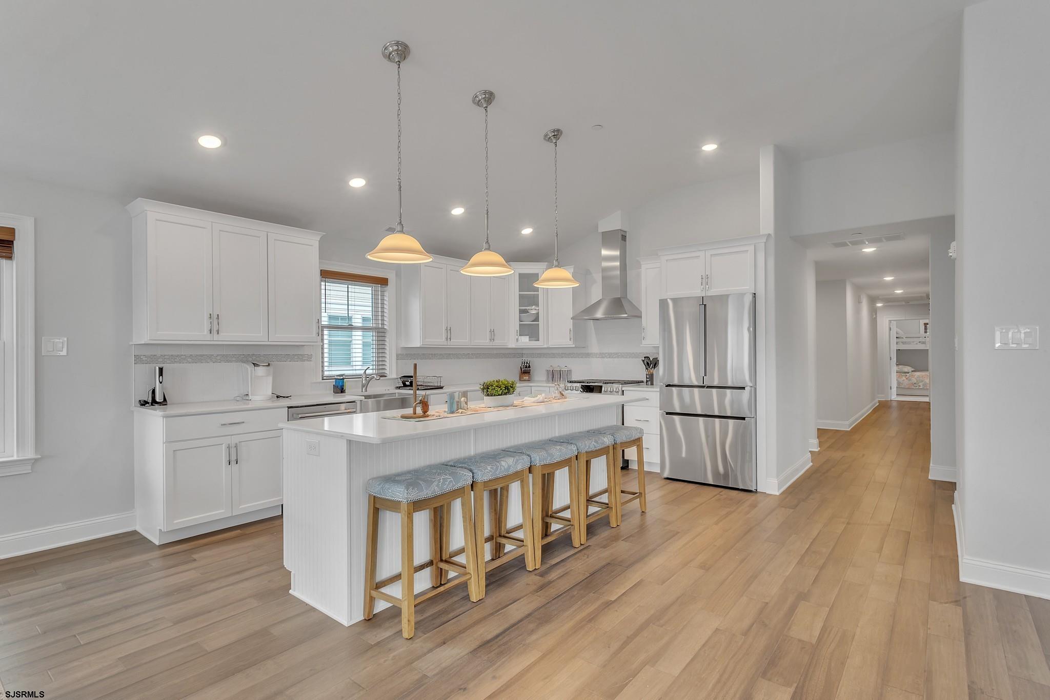 910 Ocean Avenue, Unit C Ocean City, NJ 08226 - Photo 3 of 30 a kitchen with stainless steel appliances kitchen island wooden floors stove and white cabinets