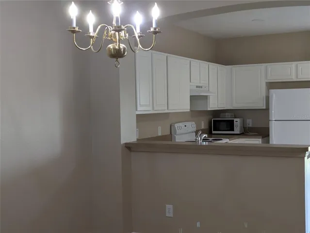 a kitchen with stainless steel appliances granite countertop a sink a stove a refrigerator and cabinets