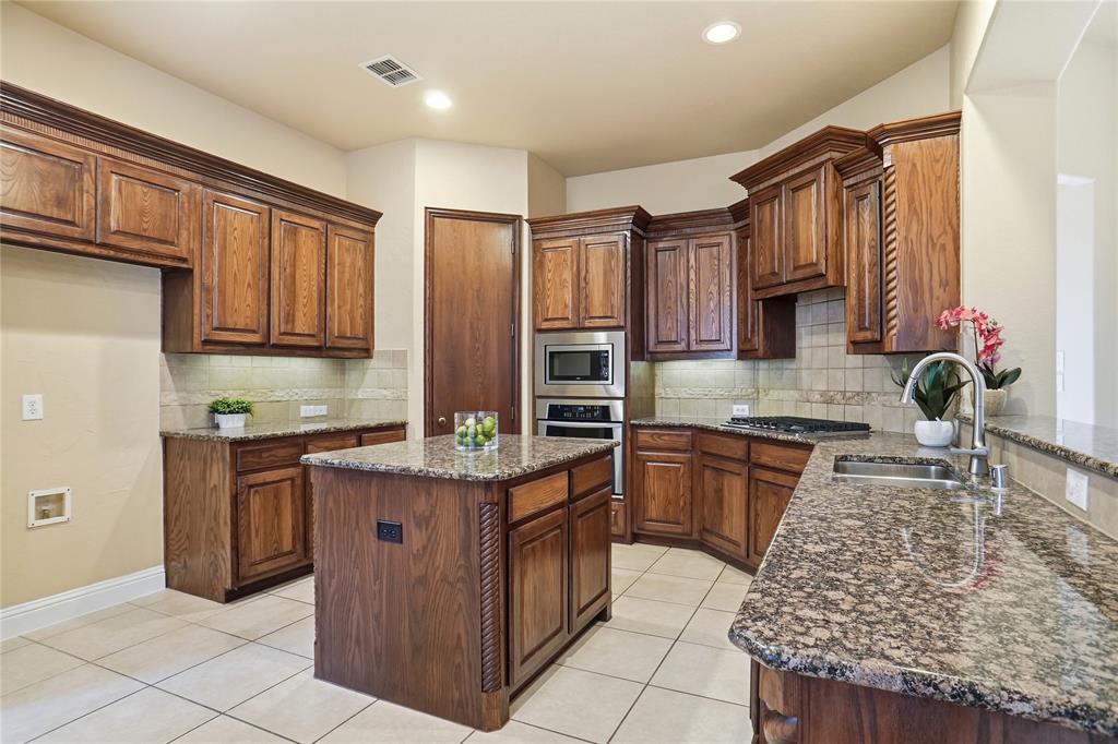 838 San Clemente Irving, TX 75039 - Photo 6 of 24 a kitchen with stainless steel appliances granite countertop a stove a sink and a microwave