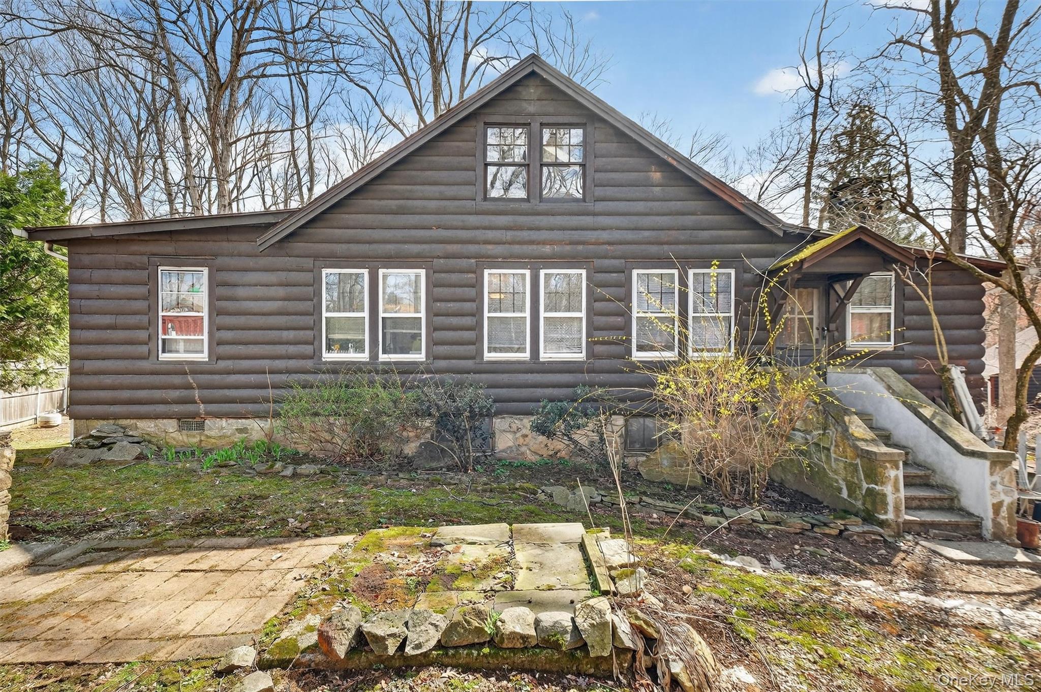 13 Perry Trail Carmel, NY 10512 - Photo 30 of 49 Rear view of the home showcasing abundant windows and charming quarter-log siding