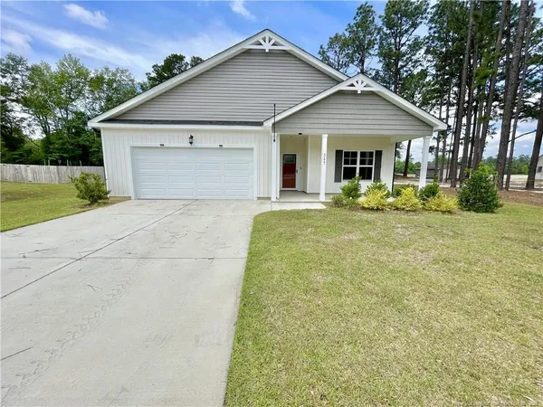 a front view of a house with a yard and garage