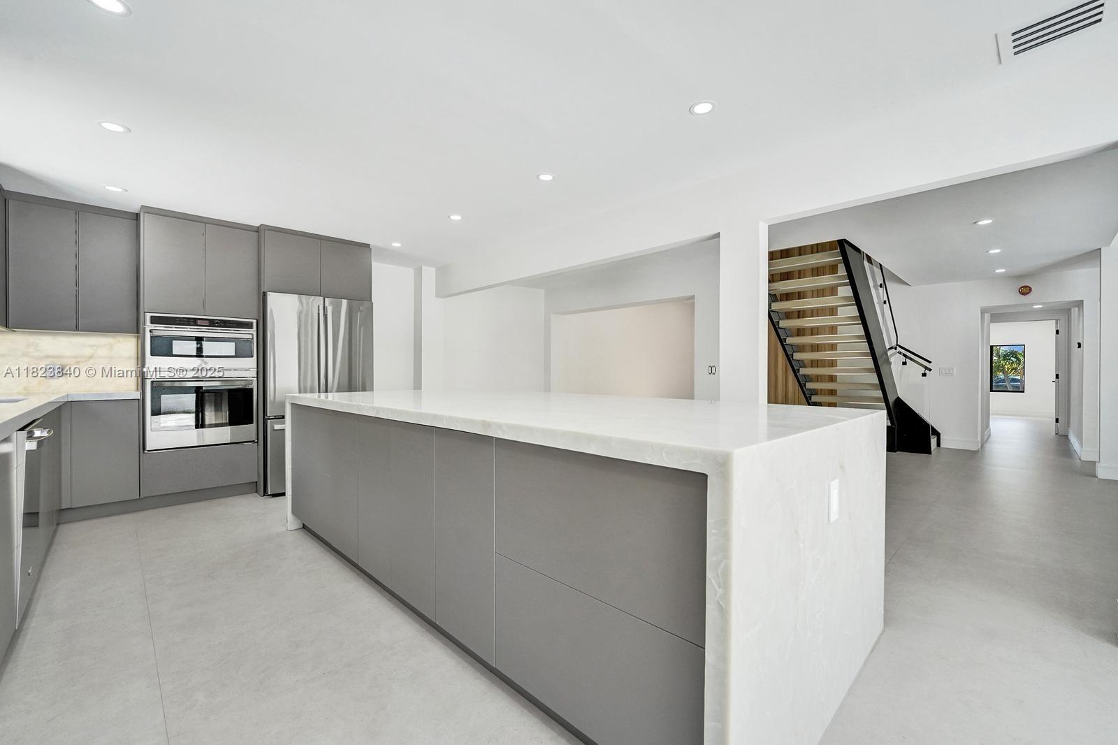 7340 Andorra Place Boca Raton, FL 33433 - Photo 15 of 99 a kitchen with stainless steel appliances a refrigerator sink and cabinets