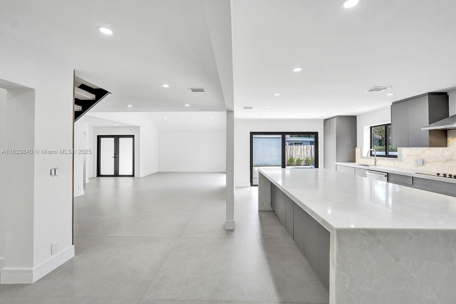 7340 Andorra Place Boca Raton, FL 33433 - Photo 64 of 99 a large white kitchen with kitchen island a sink stainless steel appliances and cabinets
