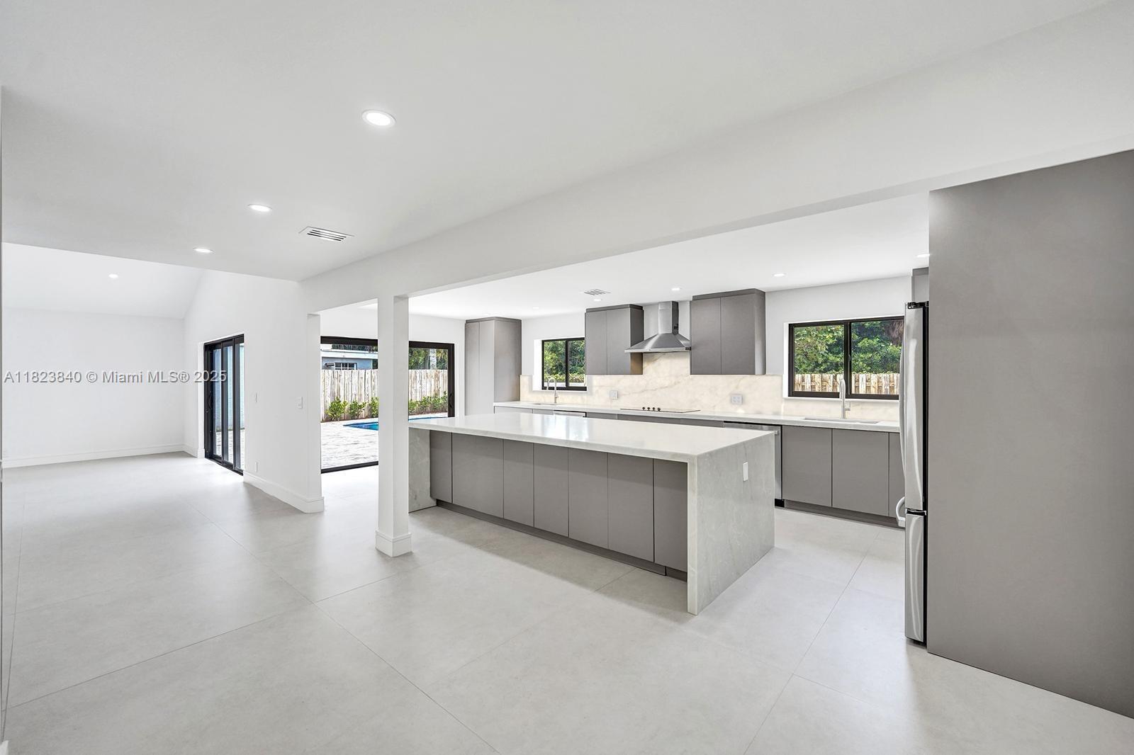 7340 Andorra Place Boca Raton, FL 33433 - Photo 8 of 99 a large white kitchen with a stove a sink a refrigerator and white cabinets with wooden floor