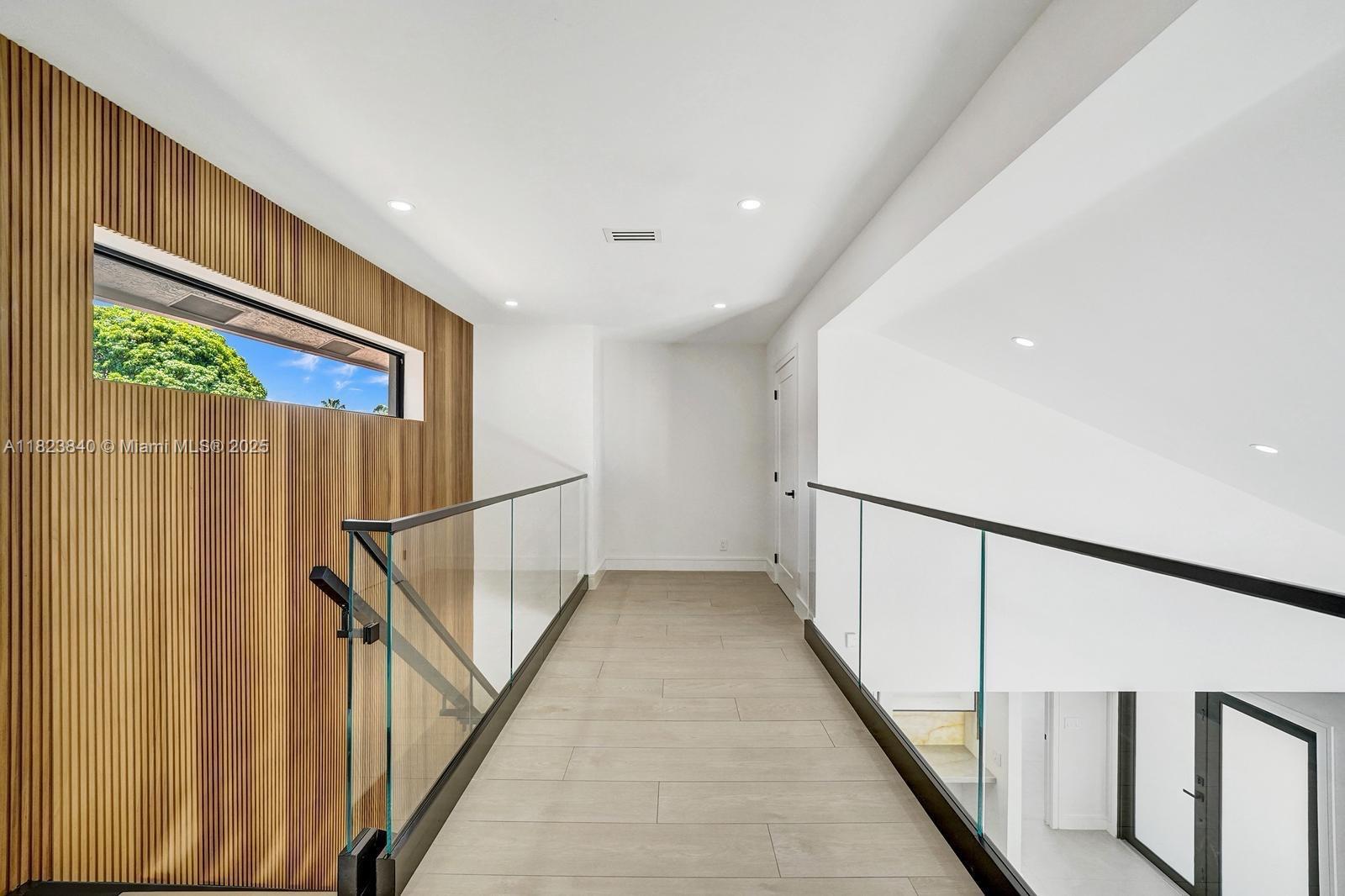 7340 Andorra Place Boca Raton, FL 33433 - Photo 86 of 99 a view of staircase with lots of frames on wall and wooden floor