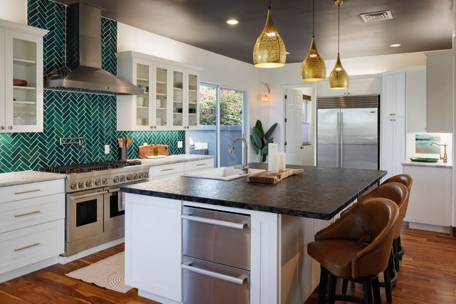 a kitchen with stainless steel appliances granite countertop a sink and a refrigerator